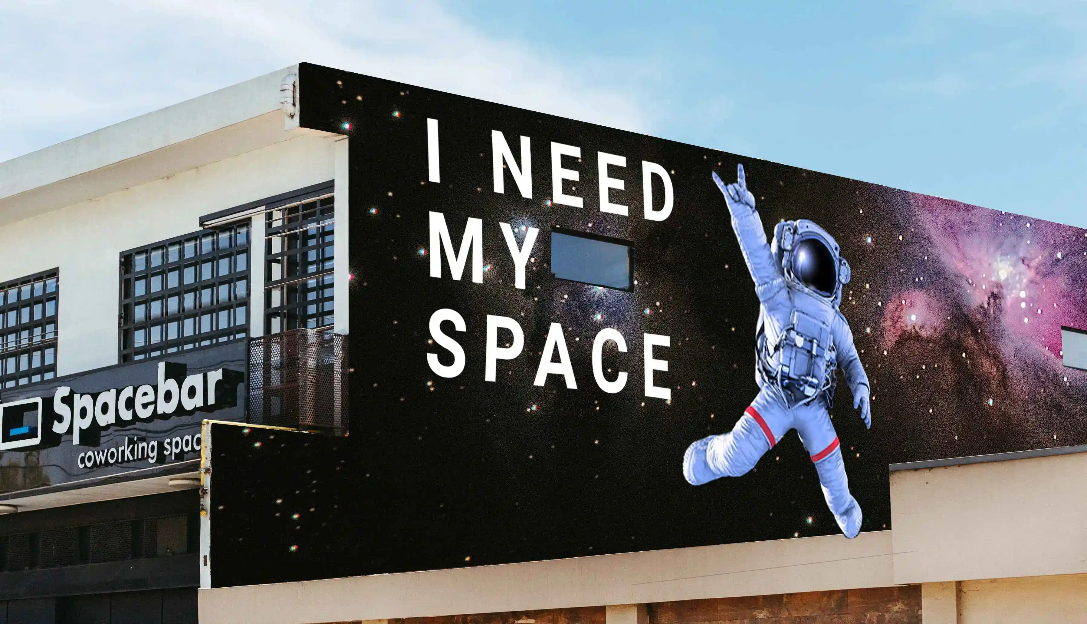 Mural que representa a un astronauta flotando en el espacio con la frase "I NEED MY SPACE" y el logotipo de Spacebar coworking space.