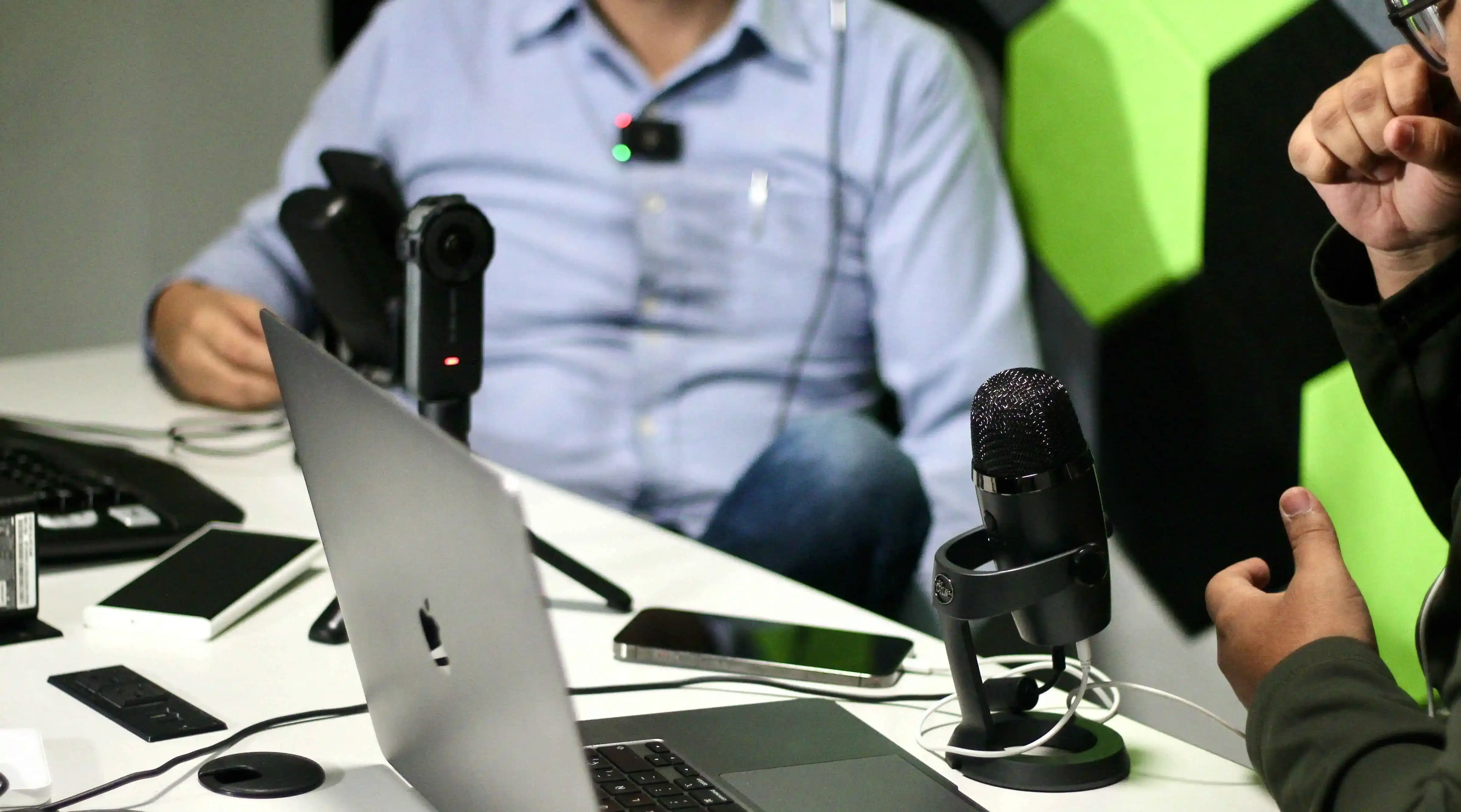 Un hombre graba audio con una computadora portátil y un micrófono.